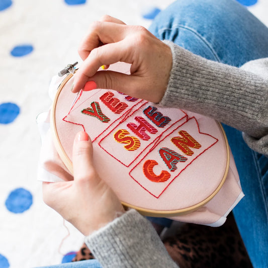 Femme en train de broder un motif de la marque Cotton Clara
